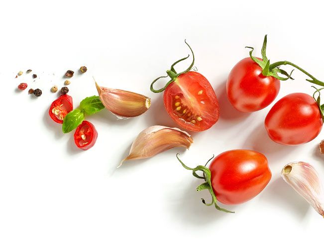 Cherry Tomaten, Knoblauch, Basilikum und Pfeffer auf weißem Hintergrund